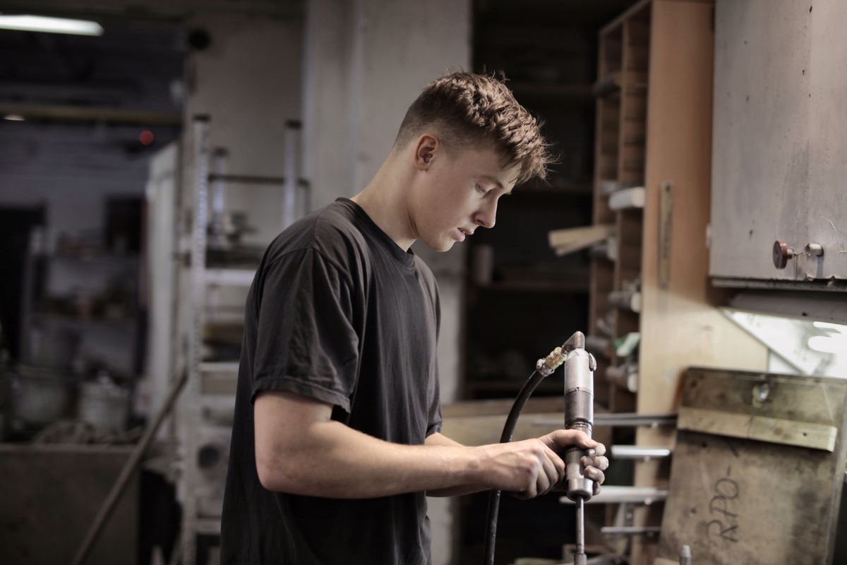 Junger Mechaniker bei der Arbeit in einer Werkstatt